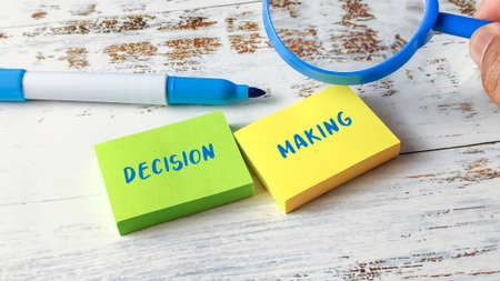 Magnifying Glass Focusing on "Decision Making" Written on Green and Yellow Sticky Notes, Illustrating Business Analysis and Choiceの写真素材