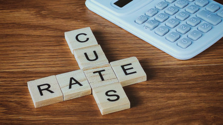 Wooden Blocks Spelling "Cut Rates" and "Cuts" Crossword with Calculator on Deskの写真素材