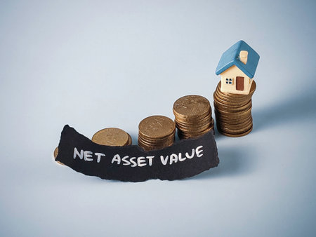 Miniature House on Rising Stacks of Coins with "Net Asset Value" Text: Concept for Real Estate Investment Growth and Financial Performanceの写真素材
