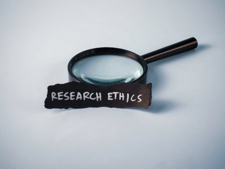 Magnifying Glass and Piece of Paper with "Research Ethics" Text: Concept for Scrutiny, Integrity, and Moral Standards in Scienceの写真素材