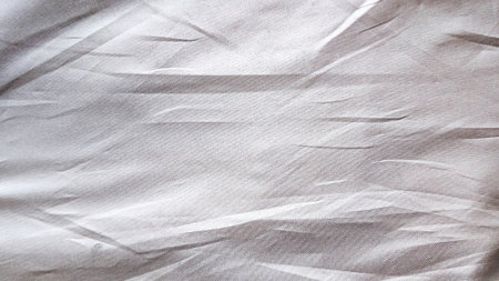 Subtle Light Grey Crinkled Sheer Fabric Texture Background with Gentle Folds and Translucent Material for Abstract Designの写真素材