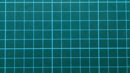Dark Teal Green Self-Healing Cutting Mat Close-Up with Bright Blue Grid Lines and Textured Surface for Crafting, Design, and Hobbiesの写真素材