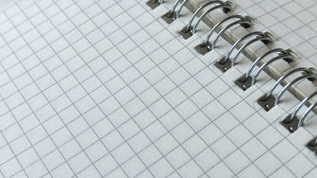 Professional spiral bound notebook with white grid paper and silver wire binding close upの写真素材