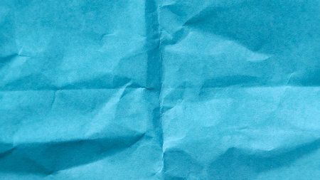 Heavily crumpled origami paper texture background with chaotic wrinkles and rough surface detailの写真素材