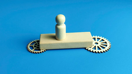 Business leadership and innovation concept with wooden figure on platform supported by gear mechanismの写真素材