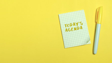 Yellow grid paper note with Today's Agenda text and marker on a bright yellow backgroundの写真素材