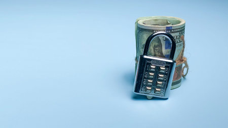 Secured roll of hundred dollar bills with a combination padlock for financial security and asset...