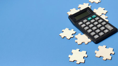 Financial problem solving and tax strategy concept with calculator and wooden jigsaw puzzle pieces