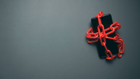 Digital Detox and Smartphone Addiction Concept with Phone Wrapped in Chains