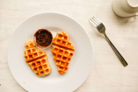 Croissant Waffle or Croffle with chocolate sauce served in box and white backgroundの写真素材