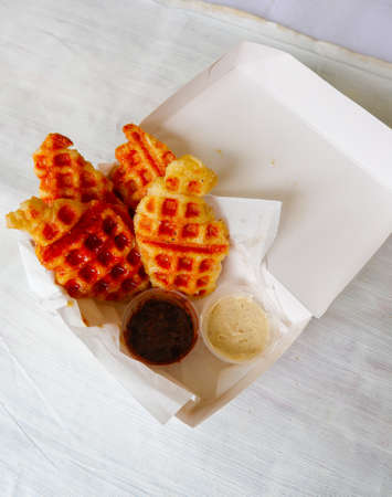 Croissant Waffle or Croffle with chocolate sauce served in box and white background