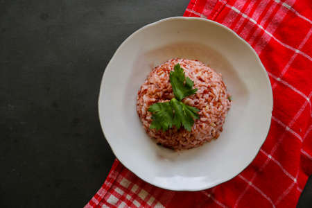 Red steamed rice or nasi merah served in plate isolated on black backgroundの写真素材