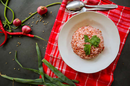 Red steamed rice or nasi merah served in plate isolated on black backgroundの写真素材