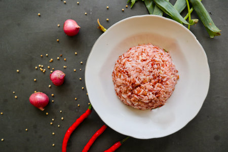 Red steamed rice or nasi merah served in plate isolated on black backgroundの写真素材