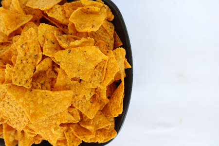 tortilla chip is corn chips or call nachos, served in bowl, on black background
made from corn