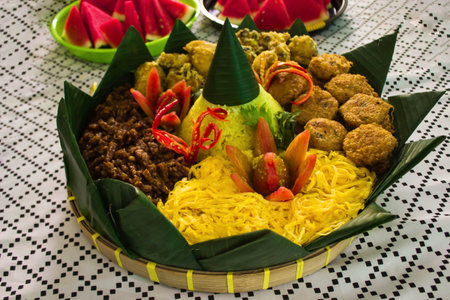 "nasi kuning or yellow rice is traditional food from javanese,  indonesia served with fried chicken, perkedel or potato dumplings, 
egg rolls and orek tempe on white background"の写真素材