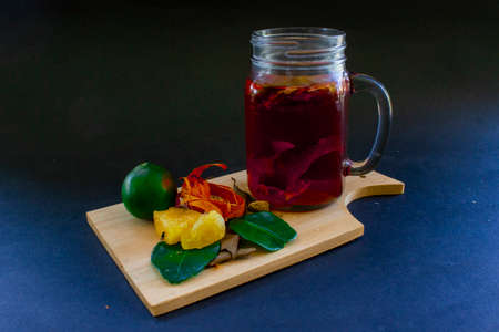 wedang uwuh is traditional herbal drink from indonesia.  made from cinnamon, nutmeg and cloves leaves. Another ingredient is wood from the secang tree, ginger and lump sugar on black backgroundの写真素材