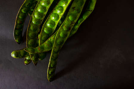 Pete or Petai, Twisted cluster bean, Stink bean, Bitter Bean, Parkia speciosa seeds, isolated on black backgroundの写真素材