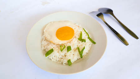 fried egg rice. breakfast fried egg sunny side rice on a plate, isolated on white backgroundの写真素材