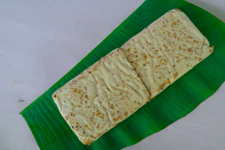 Raw tempeh or tempe. tempeh slices in white background. raw soybean seeds. Tempe is a traditional Indonesian food made from fermented soybeans.の写真素材