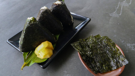 Onigiri is Japanese food, Japanese rice ball, rice triangle with seaweed, nori isolated on with backgroundの写真素材