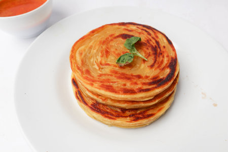 paratha bread or canai bread or roti maryam, favorite breakfast dish. served on plateの素材 [FY310194591058]