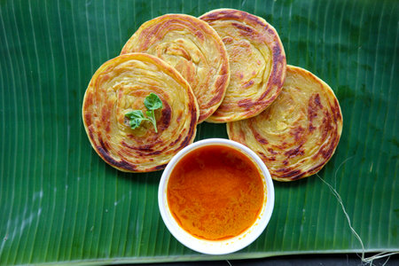 paratha bread or canai bread or roti maryam, favorite breakfast dish. served on banana leave