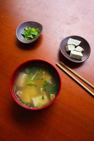 miso soup or Japanese miso soup in bowl on the table. Japanese cuisine in the form of soup with dashi ingredients, tofu, seafood, vegetables, and topped with miso to tasteの写真素材