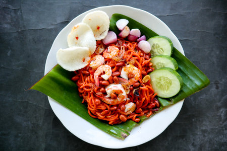 Mi Aceh, Mie Aceh or Acehnese noodles is a spicy dish typical of Aceh consisting of thick yellow noodles, slices of beef, mutton or shrimp, sliced red onions, cucumbers with a savory and spicy curry sauce.の写真素材
