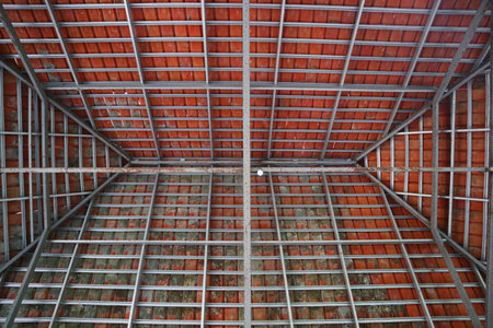 Roof construction photographed from below, composed of tiles and hollow iron