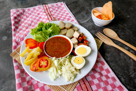 Gado-gado is a traditional Indonesian salad consisting of vegetables, potatoes, tempeh, tofu, carrots, tomatoes, lettuce, eggs, rice cake and peanut sauce. Saladの写真素材