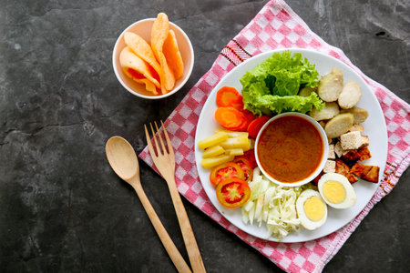 Gado-gado is a traditional Indonesian salad consisting of vegetables, potatoes, tempeh, tofu, carrots, tomatoes, lettuce, eggs, rice cake and peanut sauce. Saladの写真素材