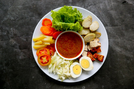 Gado-gado is a traditional Indonesian salad consisting of vegetables, potatoes, tempeh, tofu, carrots, tomatoes, lettuce, eggs, rice cake and peanut sauce. Saladの写真素材