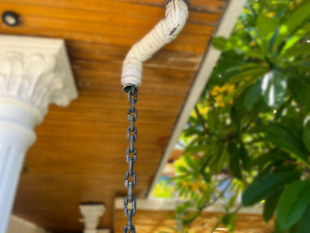 Rain chains, House rain gutter. A chain hangs from the ceiling of a patio area. The chain is...