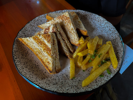 A plate of sandwiches and french fries.の写真素材