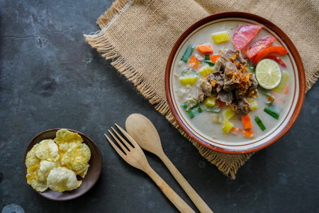 Soto Betawi is a traditional food from Jakarta, consisting of a mixture of coconut milk and milk sauce, meat, offal, emping, carrots, potatoes, lime and spices.の写真素材
