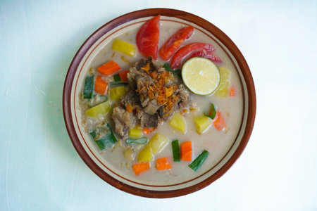 Soto Betawi is a traditional food from Jakarta, consisting of a mixture of coconut milk and milk sauce, meat, offal, emping, carrots, potatoes, lime and spices.の写真素材