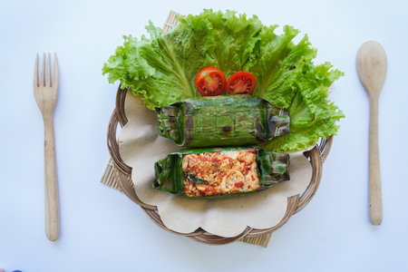 Nasi bakar is an Indonesian food, rice wrapped in banana leaves and then grilled. Rice filled with spices, chili sauce, shredded chicken, meat or fish.の写真素材