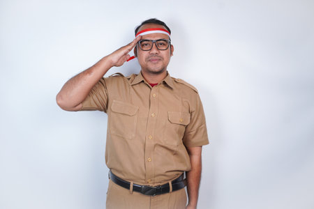 a man Asian civil servants or state civil servants is with brown uniform and red and white Headband gesture order arm, salute pose . On white background. Indonesia PNS, ASNの写真素材