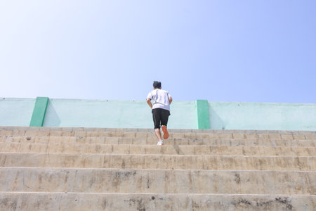 A man is running up a set of stairs. Concept of determination and perseverance as the man pushes...