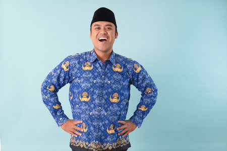 Smiling government worker man wearing kopri blue batik uniform He is posing for a picture PNS, ASN civil servant concept.の写真素材