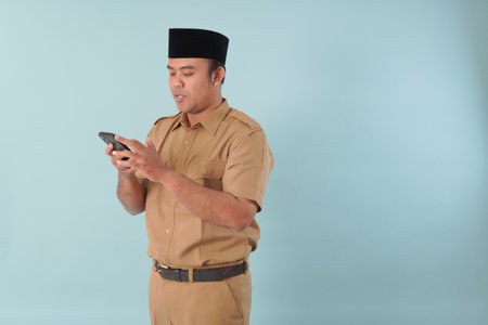 Smiling government worker with khaki uniform He is doing video call while pointing to his smartphone...