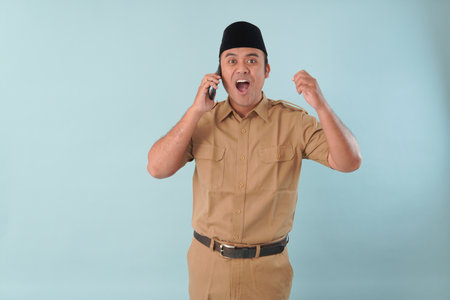 government worker man wearing is talking on his cell phone. He is smiling and he is enjoying PNS, ASN civil servant concept.の写真素材