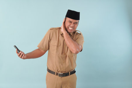 government worker man wearing is talking on his cell phone. He is smiling and he is enjoying PNS, ASN civil servant concept. holding a cell phone up to his face.の写真素材