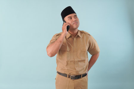 government worker man wearing is talking on his cell phone. He is smiling and he is enjoying PNS, ASN civil servant concept.の写真素材