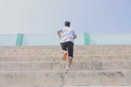 A man is running up a set of stairs. Concept of determination and perseverance as the man pushes...