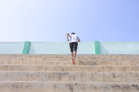 A man is running up a set of stairs. Concept of determination and perseverance as the man pushes...