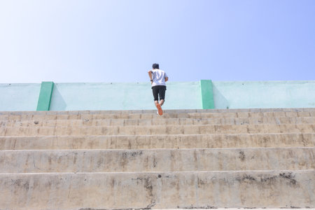 A man is running up a set of stairs. Concept of determination and perseverance as the man pushes...