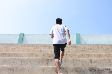 A man is running up a set of stairs. Concept of determination and perseverance as the man pushes...