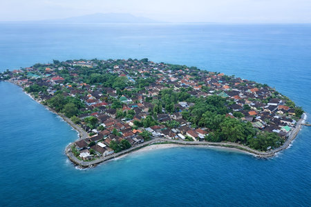 A small island with a town on it. The island is surrounded by water and the town is on the shore